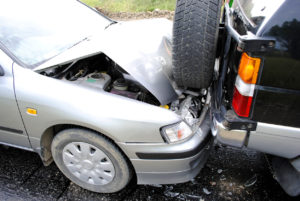 silver car with damaged front end rear-ending a jeep